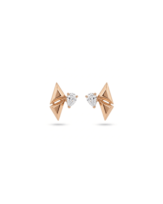 A pair of rose gold geometric stud earrings with triangular facets and a small pear-cut clear gemstone in the center, shown on a white background.