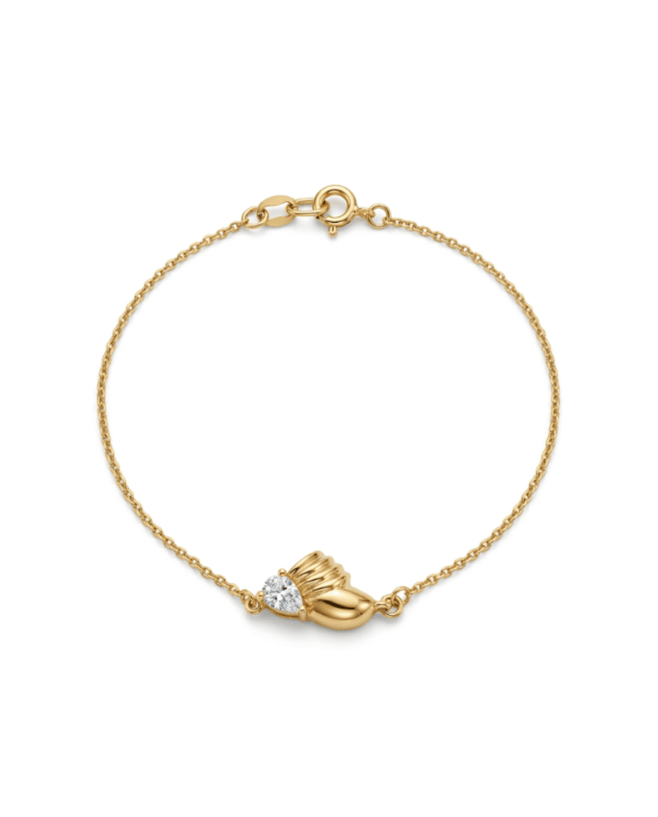 A delicate gold chain bracelet with a small gold heart-shaped charm and a clear heart-shaped gemstone, displayed on a clean white background.
