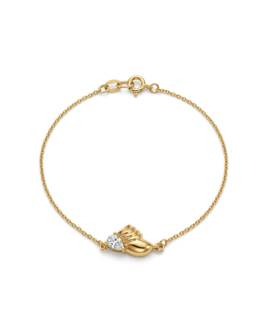 A delicate gold chain bracelet with a small gold heart-shaped charm and a clear heart-shaped gemstone, displayed on a clean white background.